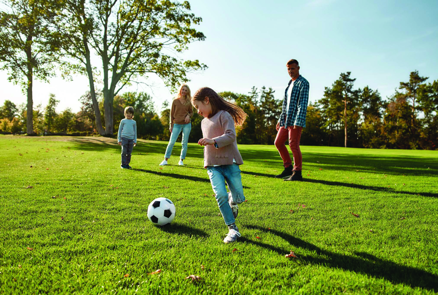 family playing soccer on the event lawn